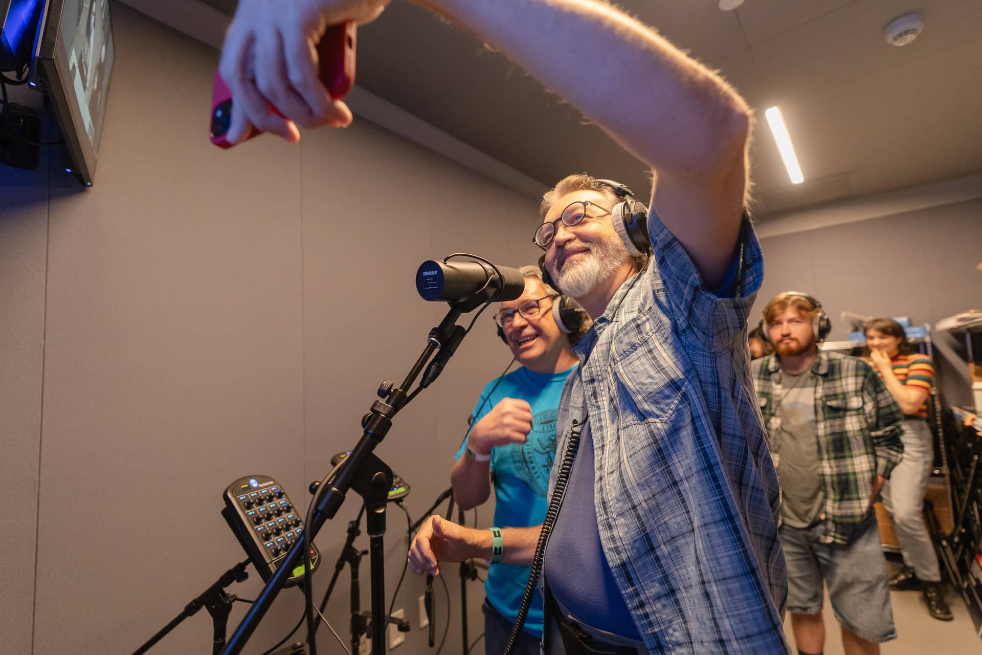 Group of Adults in a Sound booth singing